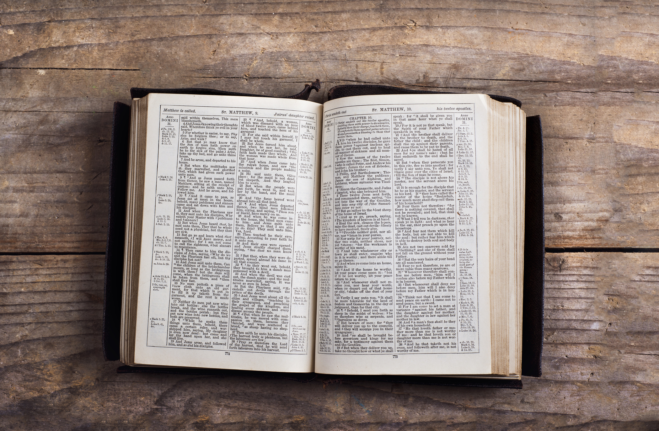 An open Bible resting on a weathered wooden table