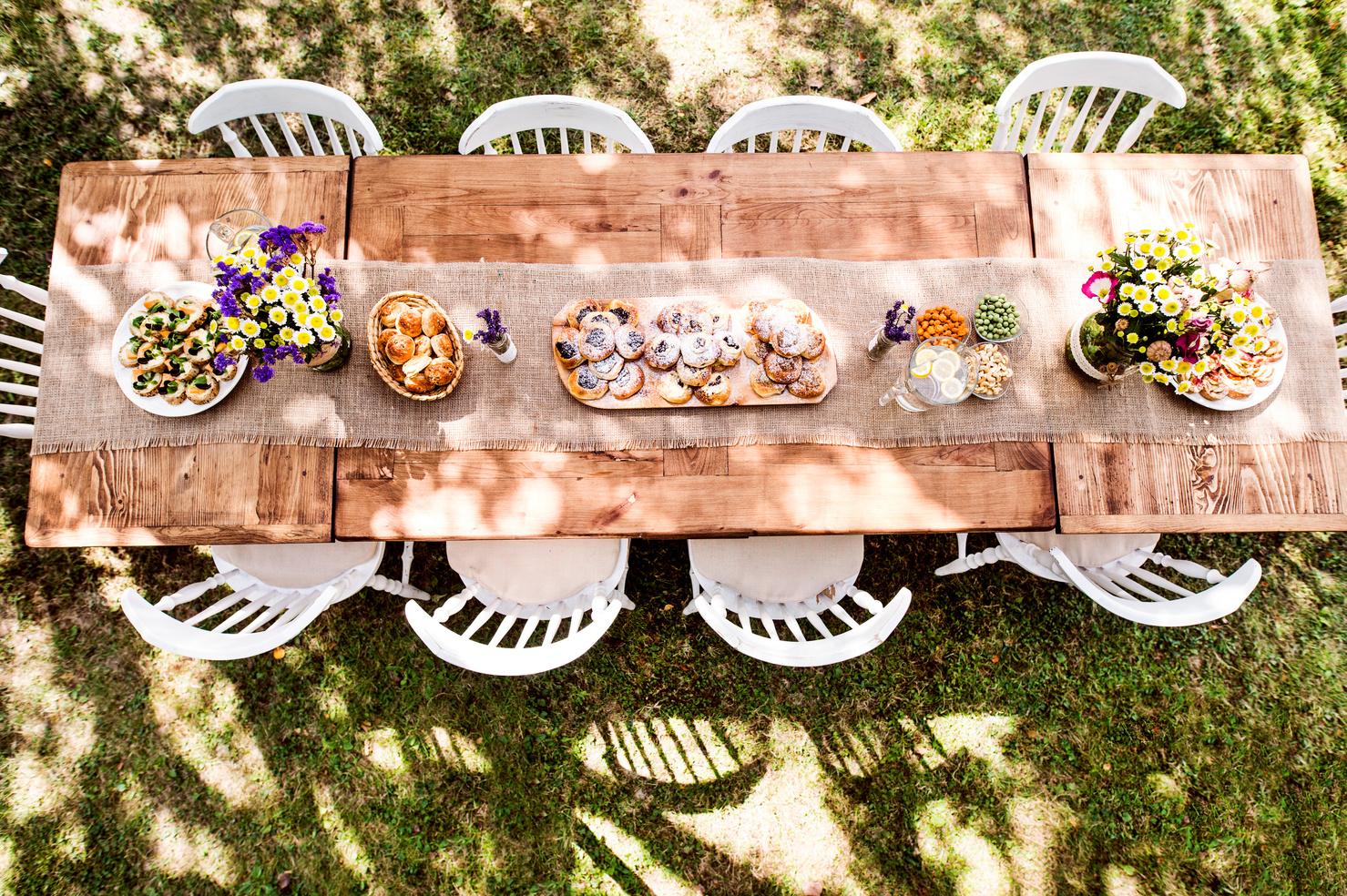 A table set outdoors with food and flowers, ready for family and friends to gather